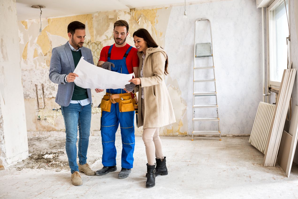 Handwerker und Bauherren bei der Planung einer Wohnungssanierung in Berlin