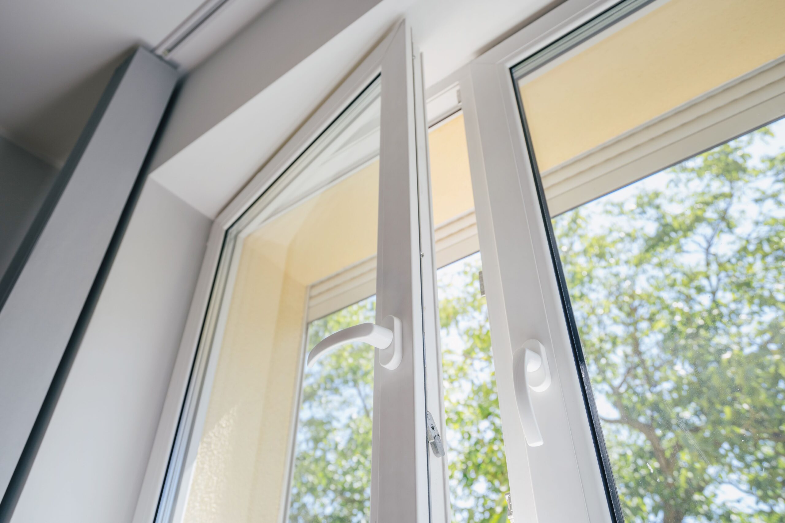 Modernes Fenster geöffnet mit Blick ins Grüne, Tageslicht strömt in den Raum