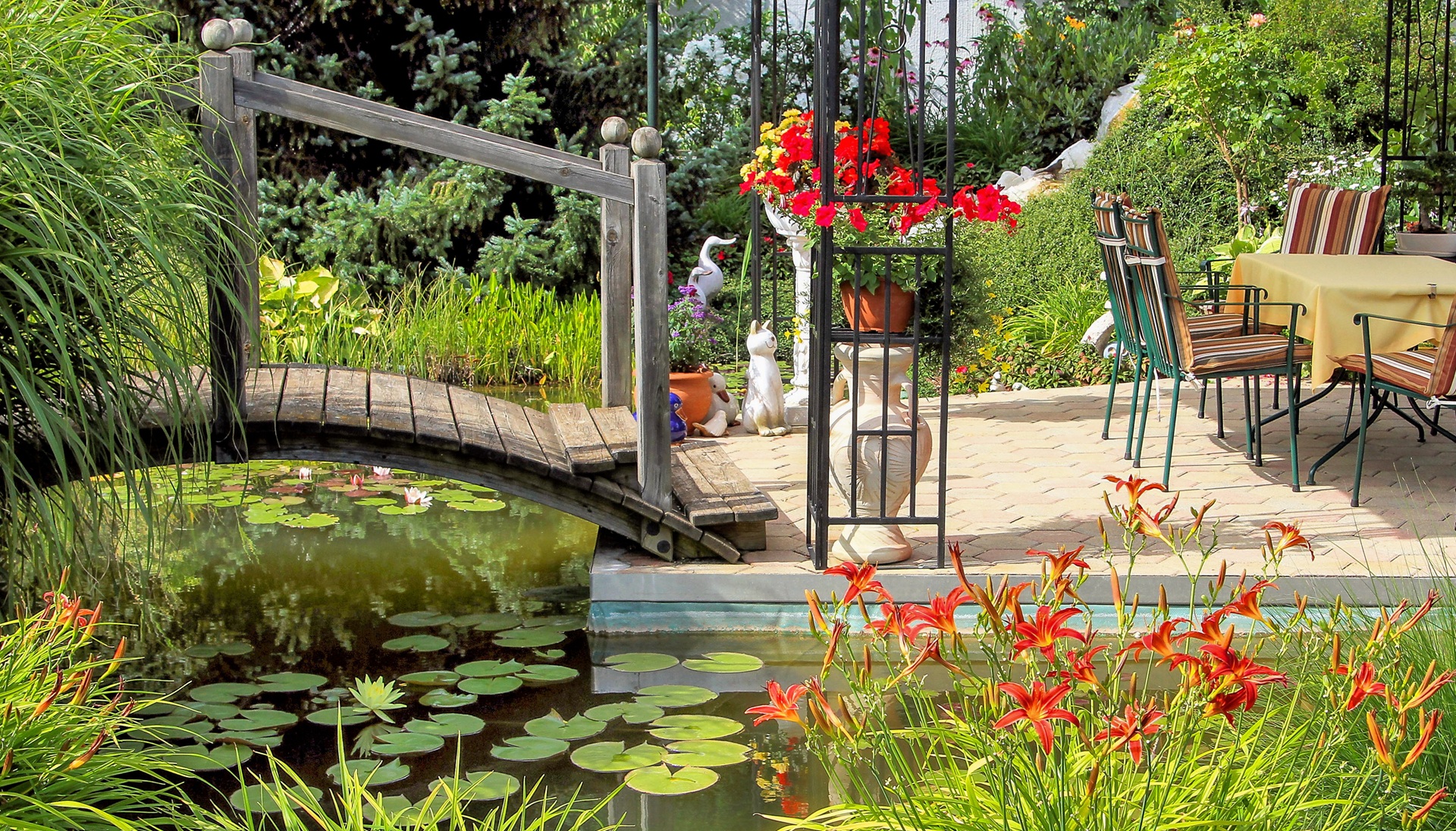 Holzbruecke ueber Gartenteich mit Sitzplatz | Stelen Garten