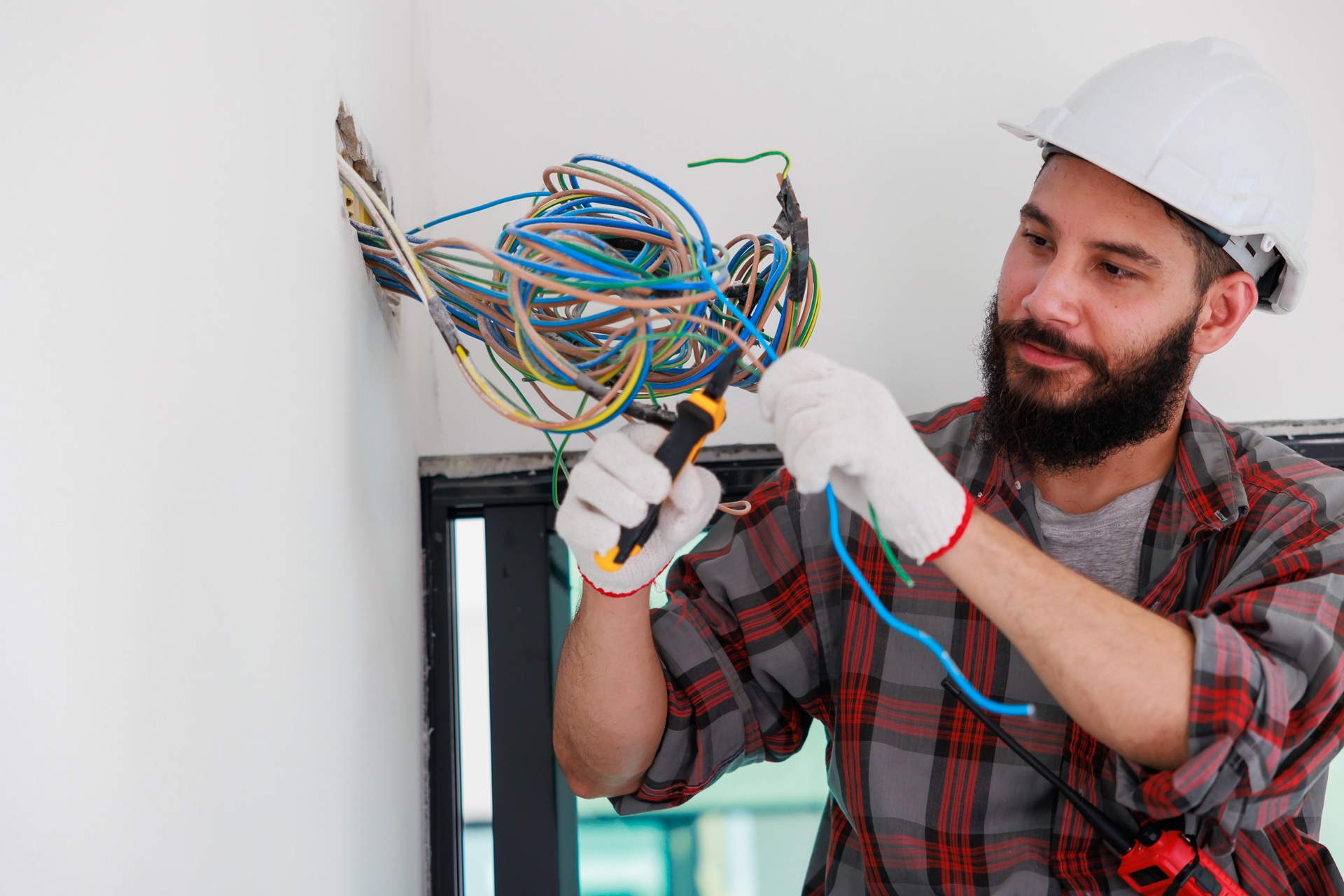 Elektriker prüft Kabel einer neuen Hausinstallation | Enthärtungsanlage