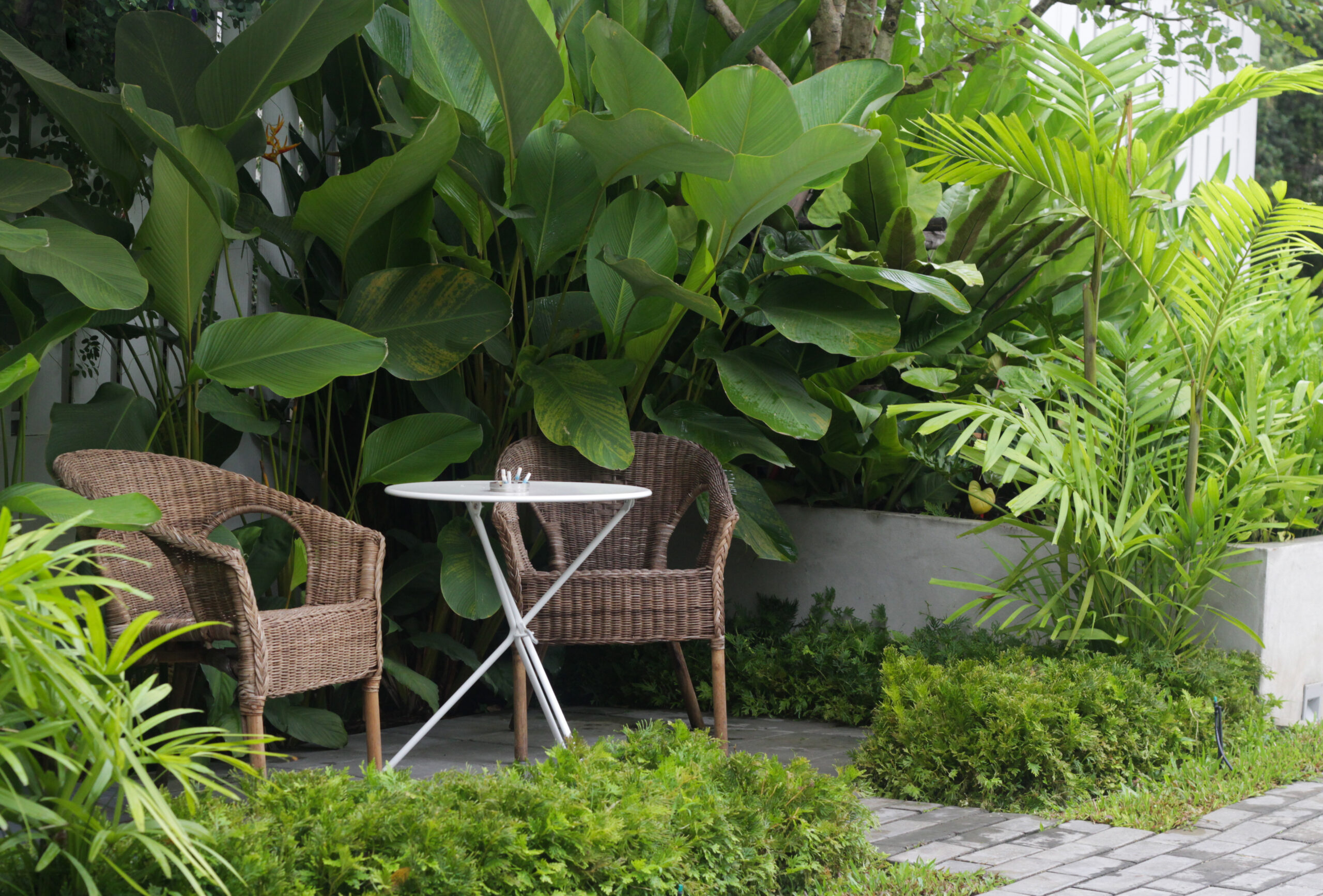 Rattanmöbel mit kleinem Tisch im Garten | Dekofiguren
