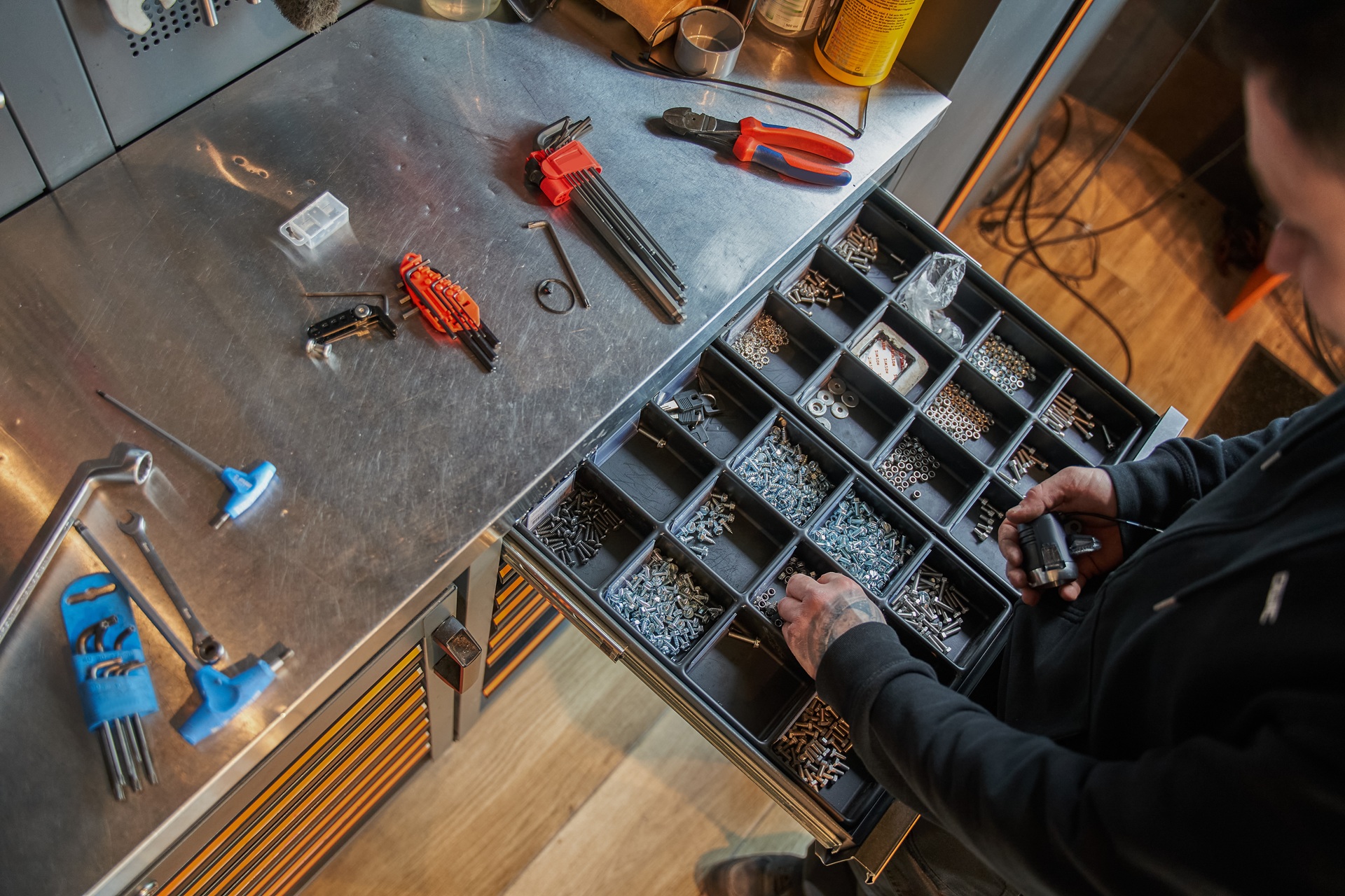 Sortierte Schrauben und Werkzeuge auf Werkbank | Bodenmarkierung